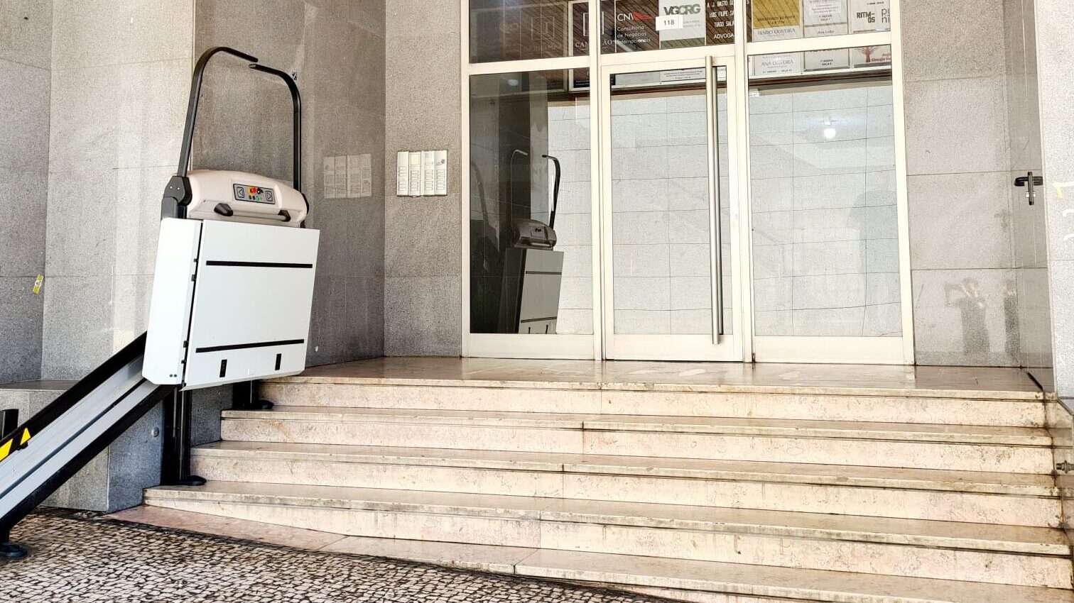 Entrada do edifício do museu Neonia Porto com plataforma elevatória para acessibilidade em cadeira de rodas e carrinhos de bebé.