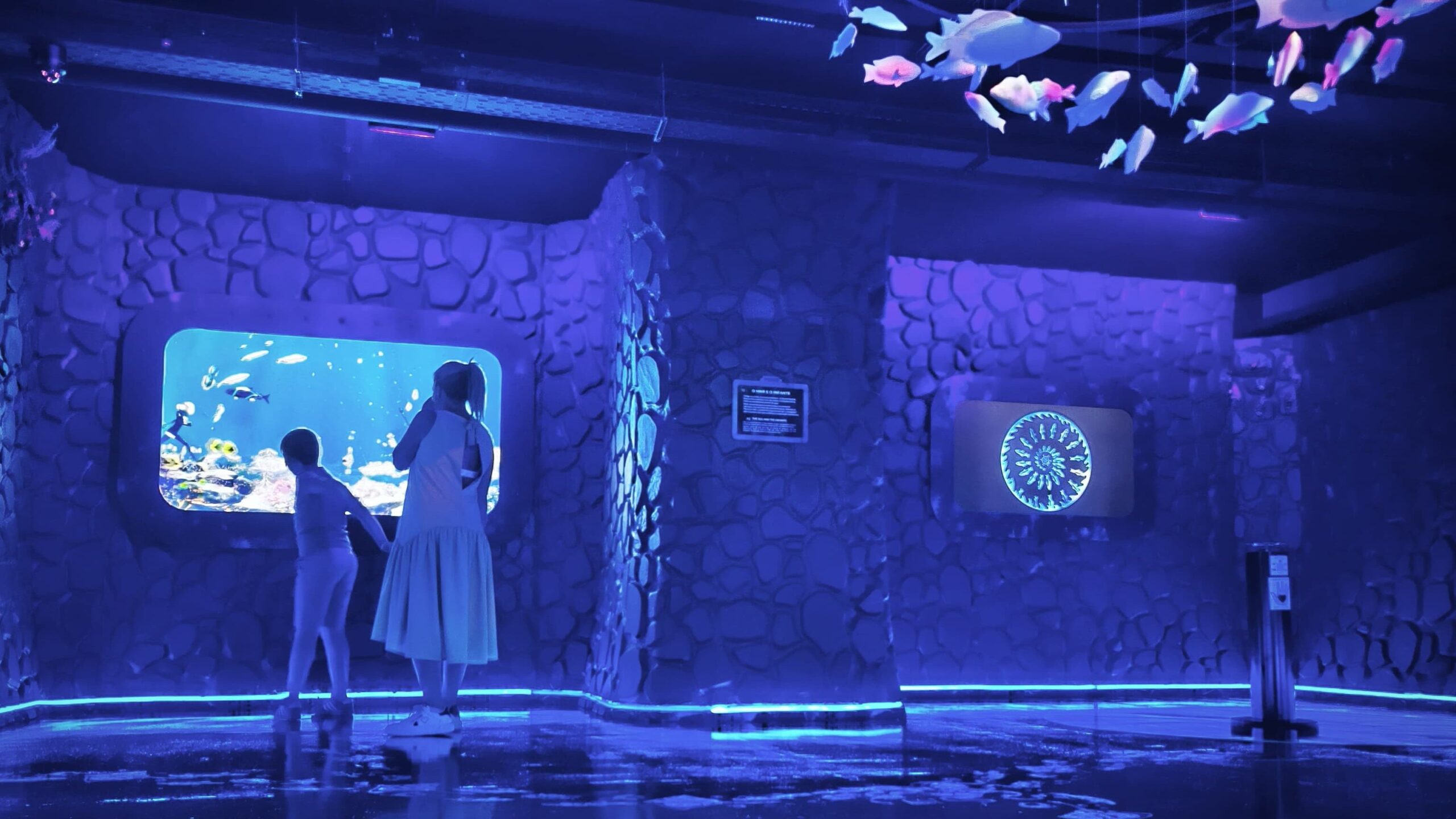 Foto de dois visitantes do museu Neonia num ambiente Snoezelen: a sala Mar.