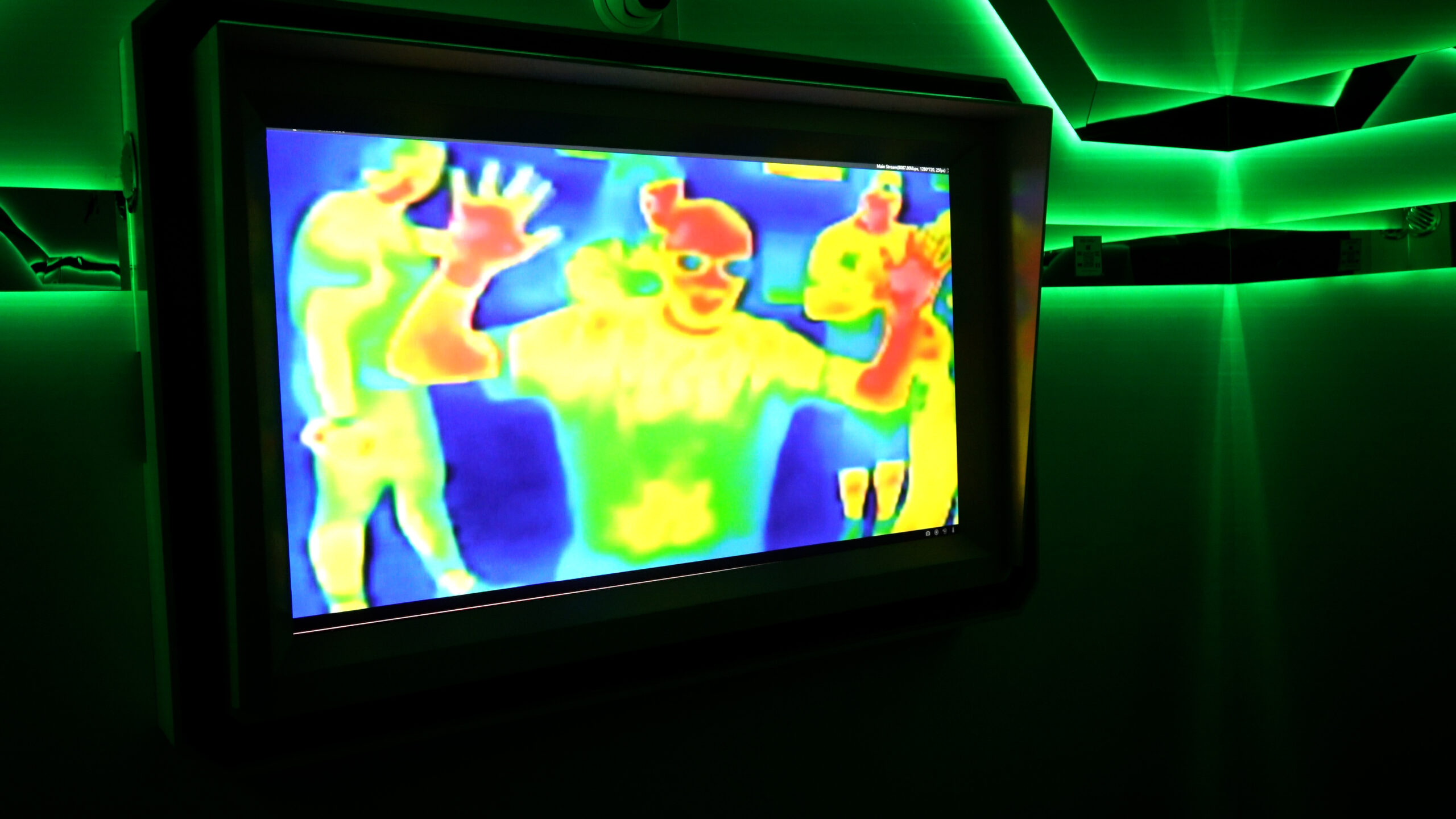 Thermal camera screen displaying colourful heat signatures of visitors inside an interactive room at Neonia Porto.